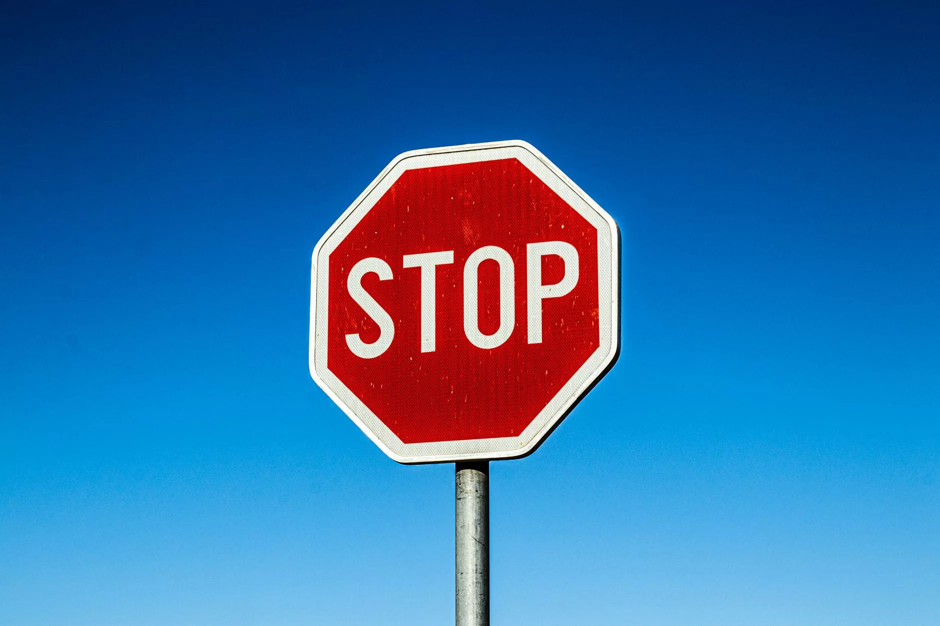 a stop sign under the blue sky